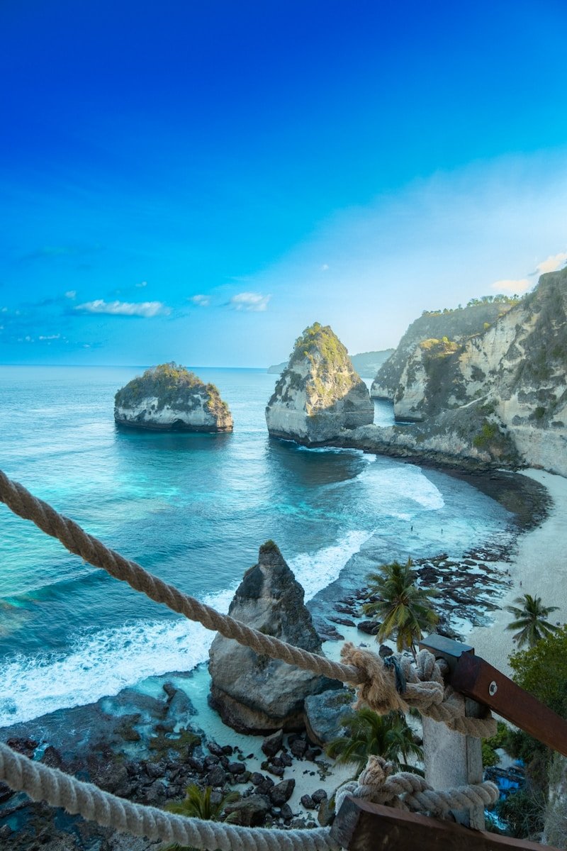 A rope hanging from the side of a cliff next to the ocean